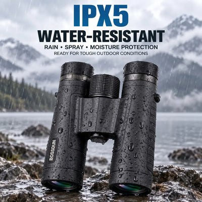 Black BOSSUN binoculars with water droplets, shown outdoors on rocks by a lake with mountains in the background, under text that reads 'IPX5 WATER-RESISTANT'.
