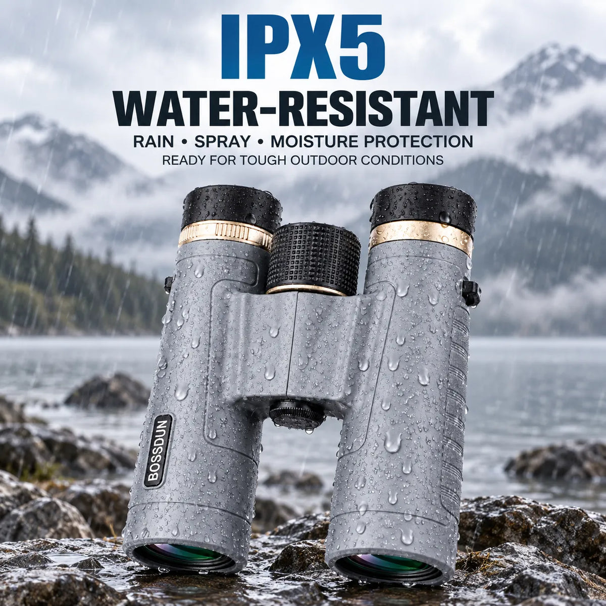 Gray BOSSUN binoculars with black and gold accents, shown outdoors on wet rocks with rain, water droplets, and misty mountains in the background. Text at the top reads 'IPX5 WATER-RESISTANT' with smaller copy about rain, spray, and moisture protection.
